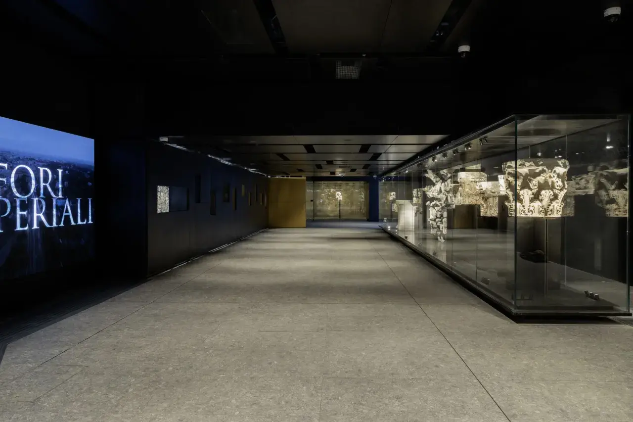 Corridoio moderno con reperti antichi esposti in teche di vetro, un omaggio ai Fori Imperiali, vicino alla metro C Roma Colosseo.