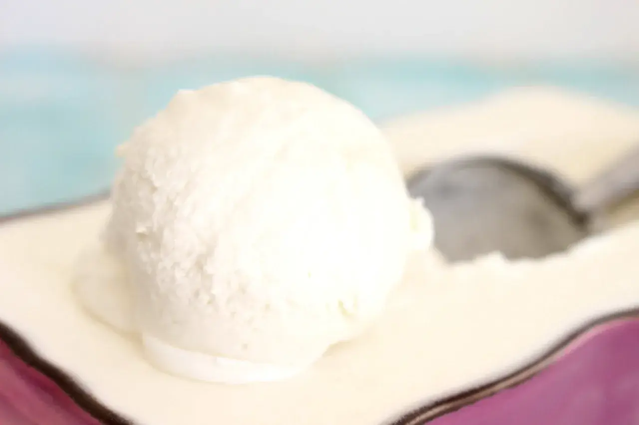 Una bola cremosa de helado de nata Thermomix sobre un plato, lista para ser disfrutada.