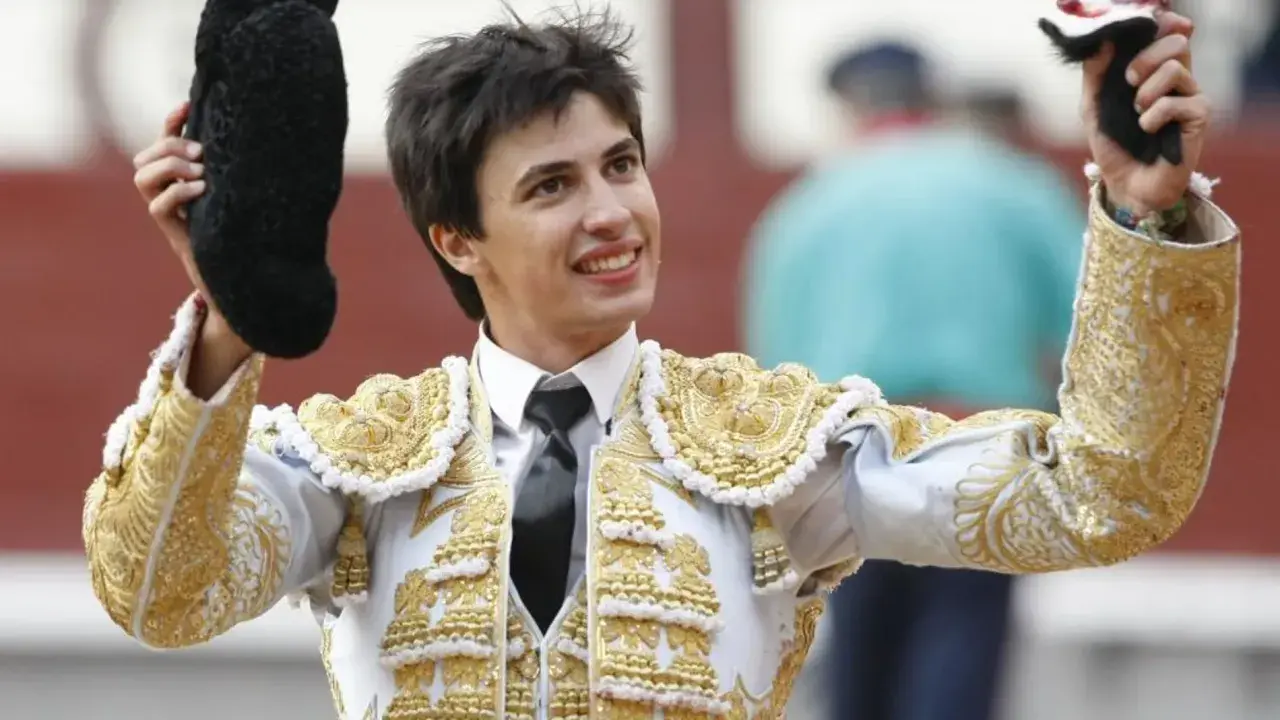 Francisco José Espada, torero, sonríe con su traje de luces dorado y blanco, alzando la montera y el capote.