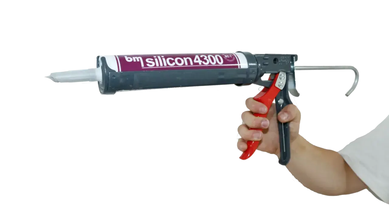 Hand hält eine Kartuschenpistole mit "bm silicon 4300" für das acryl dichtmasse entfernen.