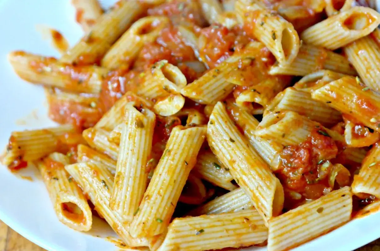 Pyszny makaron penne z aromatycznym sosem pomidorowym, posypany ziołami. Idealny na szybki obiad.