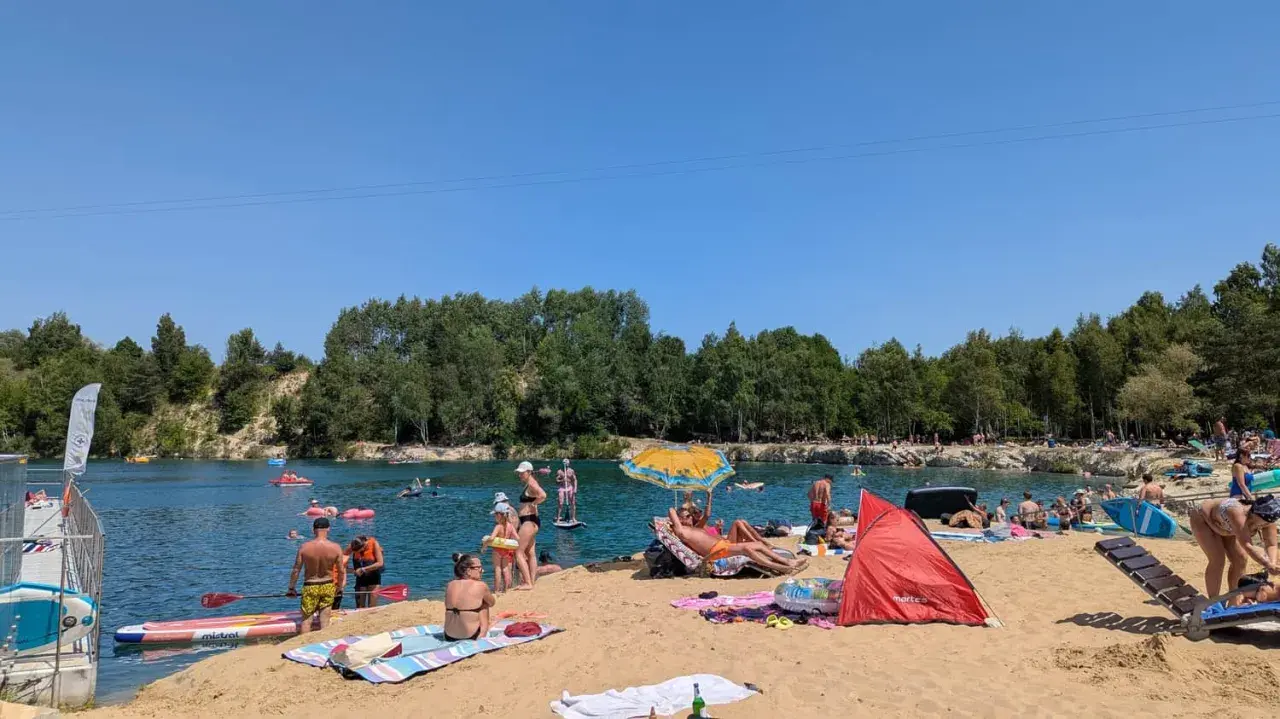 Słoneczny dzień nad zalewem Balaton Trzebinia. Ludzie odpoczywają na plaży, pływają i relaksują się w wodzie.