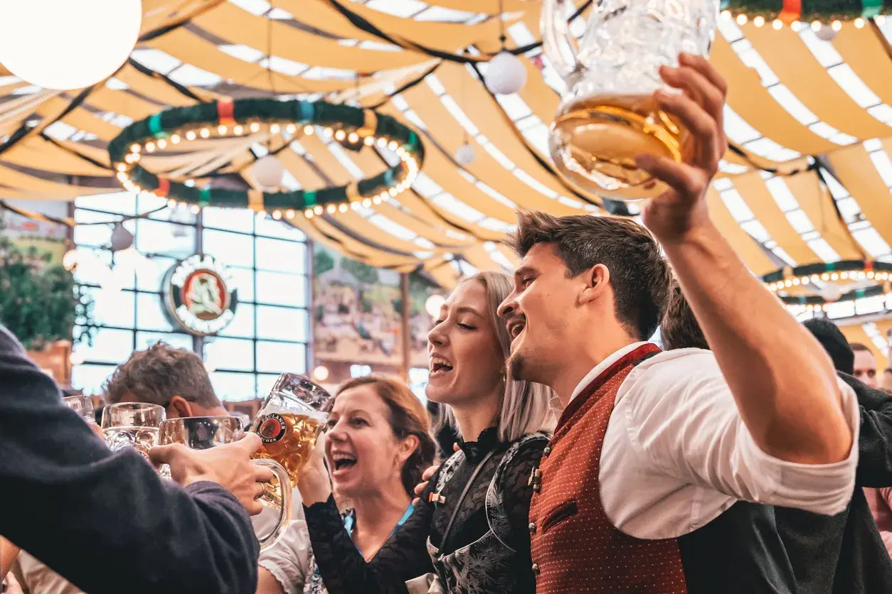 Allegra compagnia brinda con boccali di birra, festeggiando l'Oktoberfest. Litri di birra scorrono in un'atmosfera di gioia.