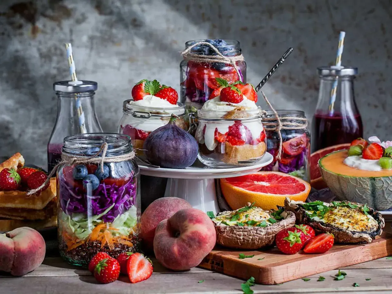 Färgglada burkar med frukt och grönsaker, perfekta för ett somrigt brunch recept. Jordgubbar, blåbär, kål och quinoa i lager.