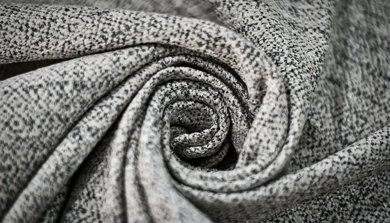 Graues, gemustertes Polyester-Material, kunstvoll zu einer Spirale gedreht.