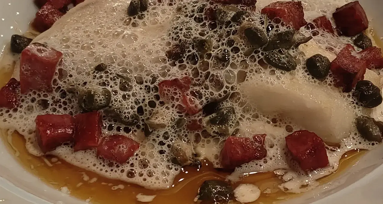 Kawałki mięsa i kaparów w pianie, jakby z eleganckiej restauracji w Danii stolicy.