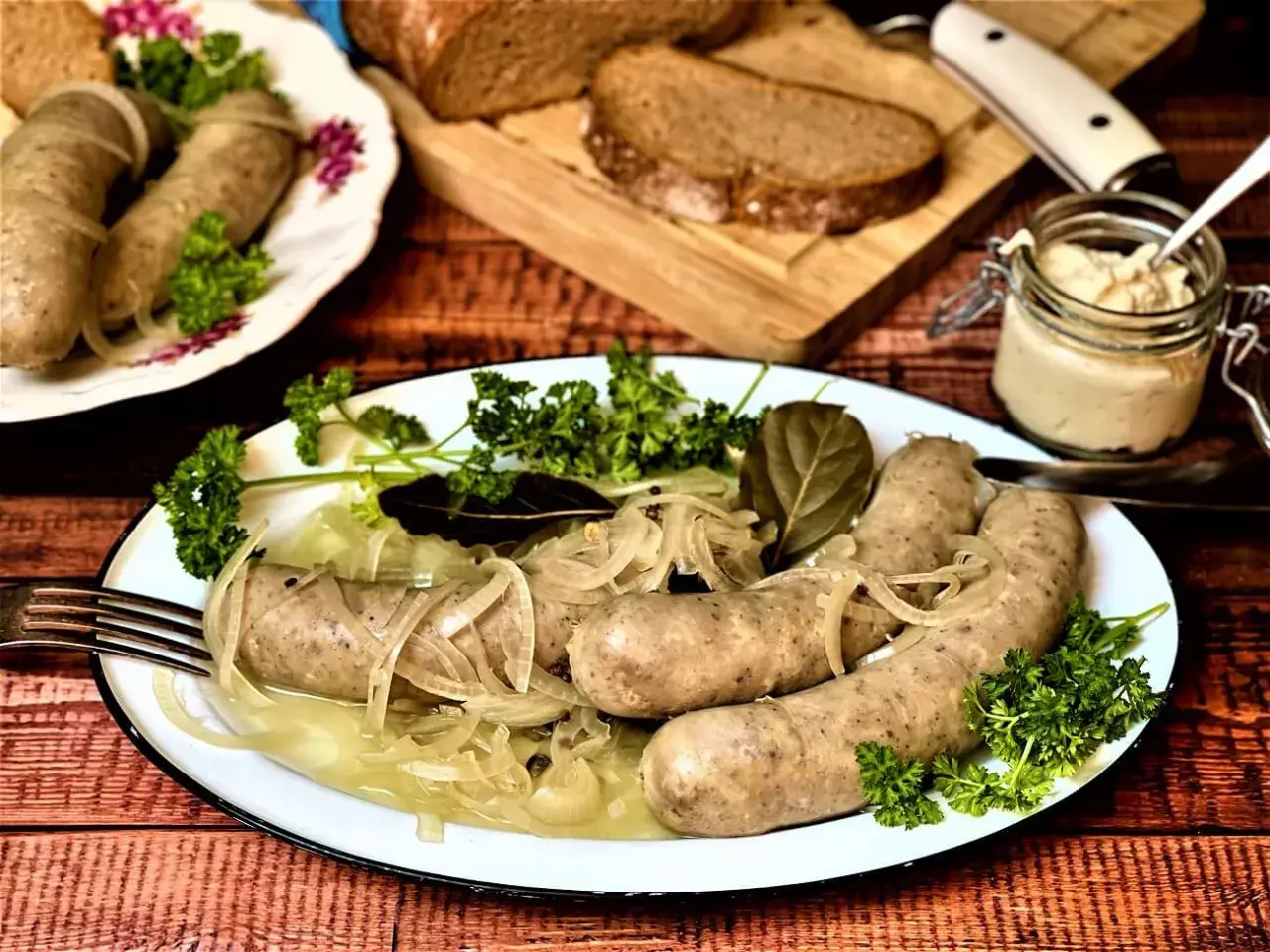 Herzhafte Würste mit Zwiebeln und Petersilie, serviert mit Brot und Dip. Was sind blaue Zipfel? Diese Würste sind ein Genuss!