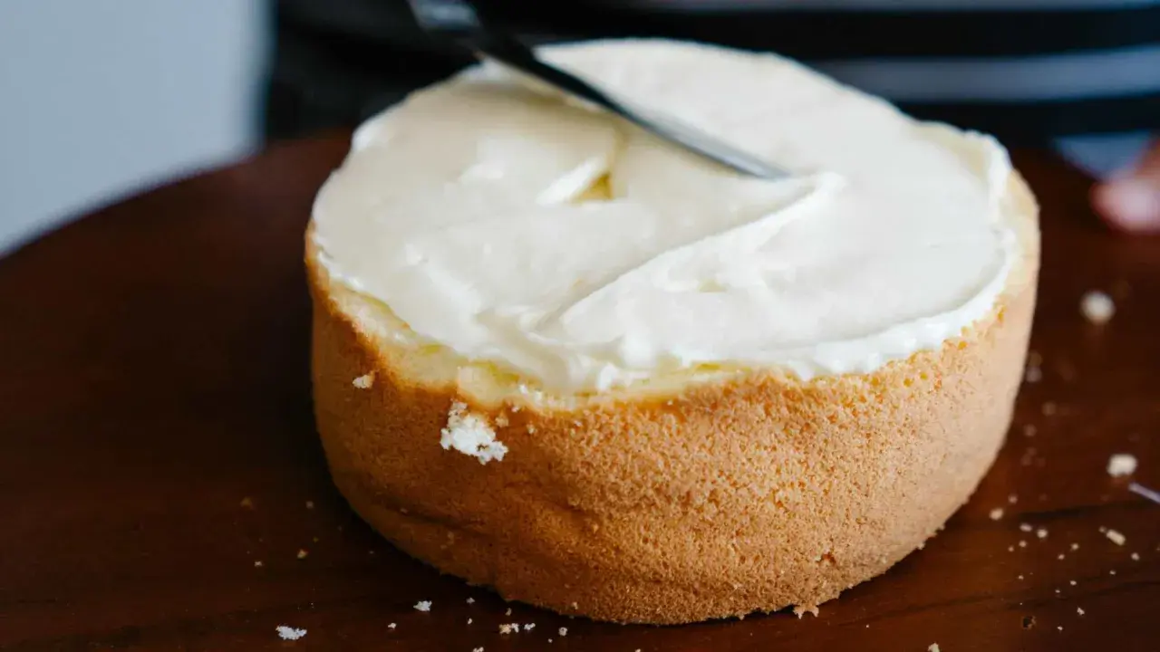 Bizcocho esponjoso cubierto con glaseado blanco cremoso, listo para decorar. Una deliciosa receta bizcocho.