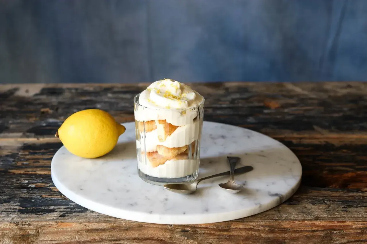 Erfrischendes Zitronen Tiramisu im Glas, garniert mit Zitronenschale. Ein leichtes Dessert, das Lust auf mehr macht.