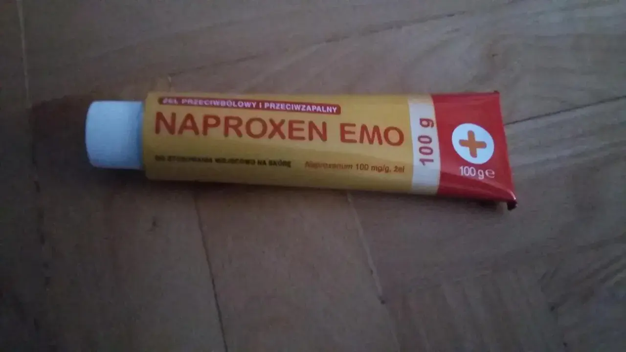 Tuba żelu Naproxen Emo 100g z białym zamknięciem na drewnianym tle.