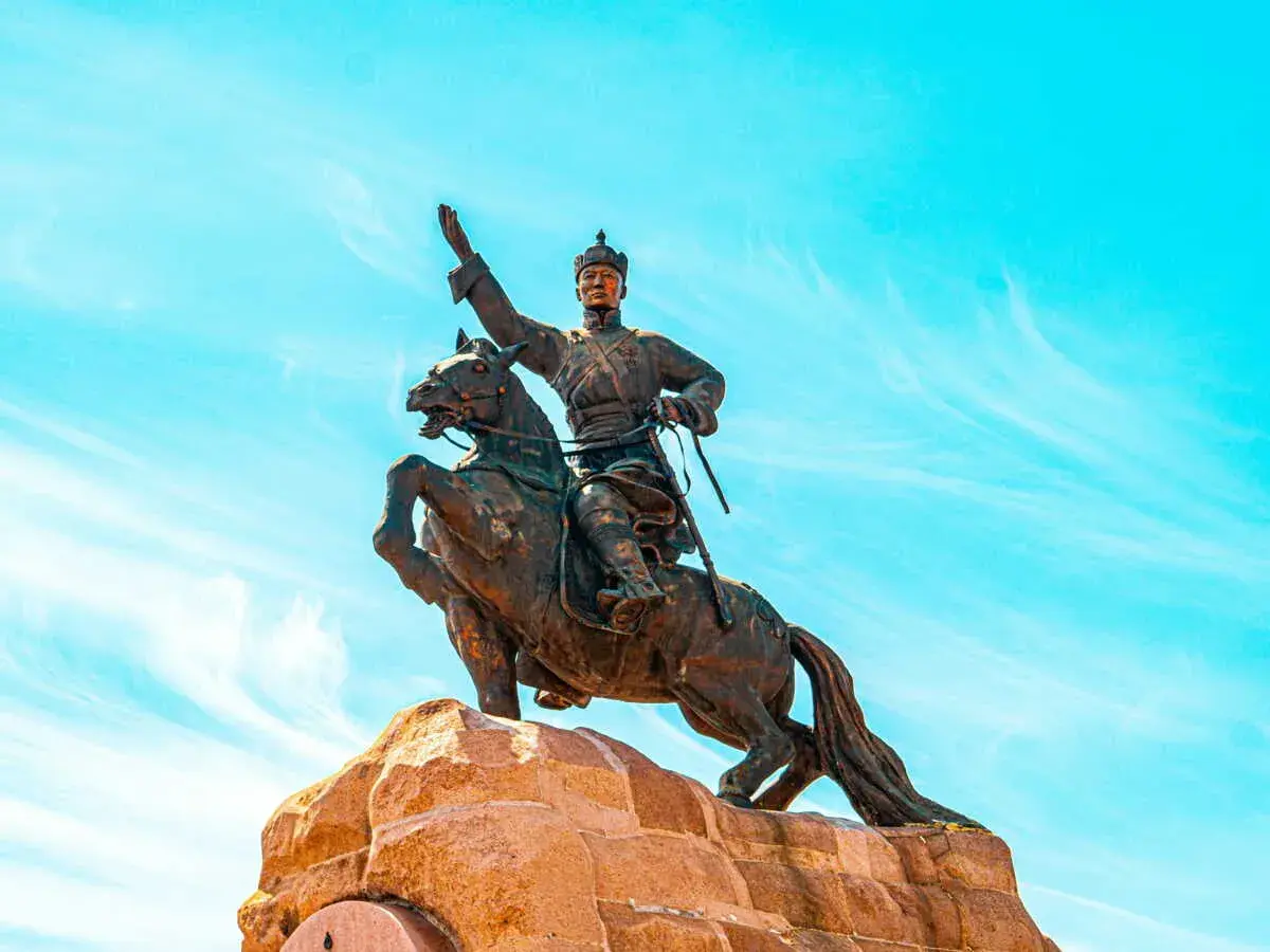 Statue équestre d'un guerrier, symbole de la descendance de Gengis Khan, sous un ciel bleu éclatant.