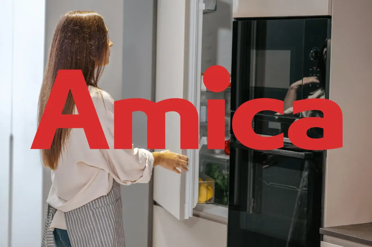 Kobieta otwiera lodówkę Amica, polską firmę znaną z produkcji sprzętu AGD.