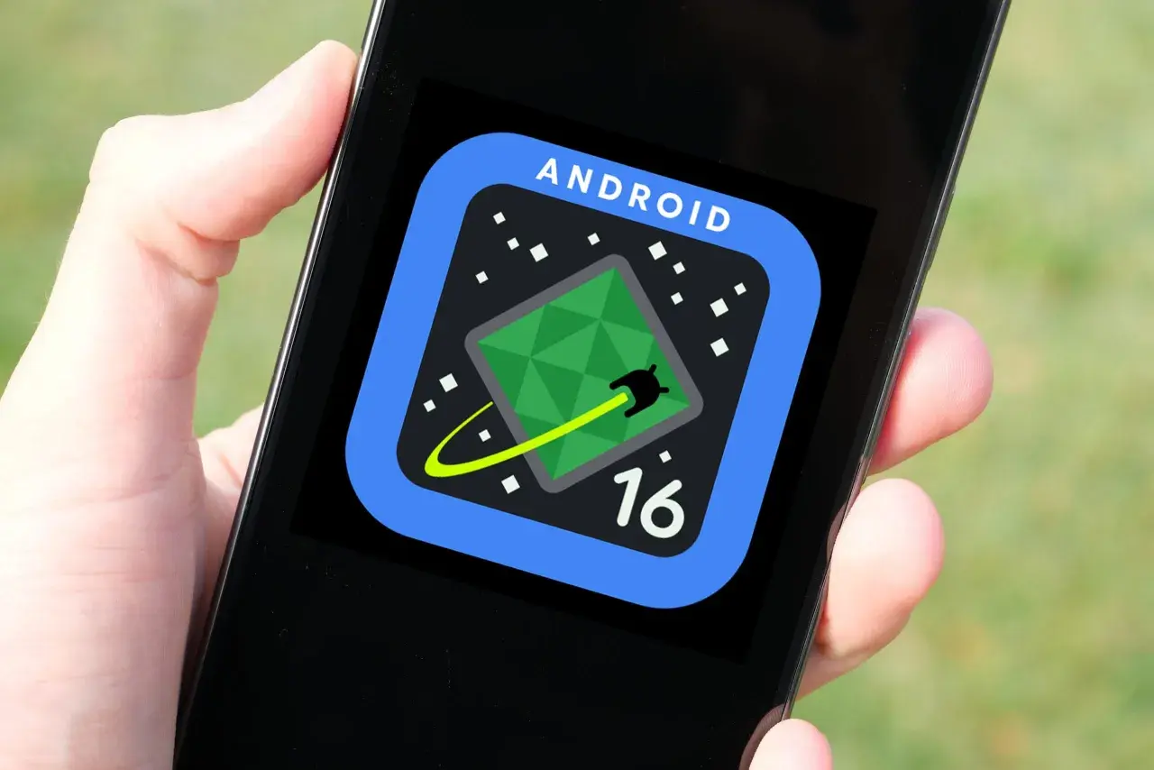 Ikona Android 16 na ekranie telefonu. Zielona, geometryczna wyspa na ciemnym tle z białymi kropkami.