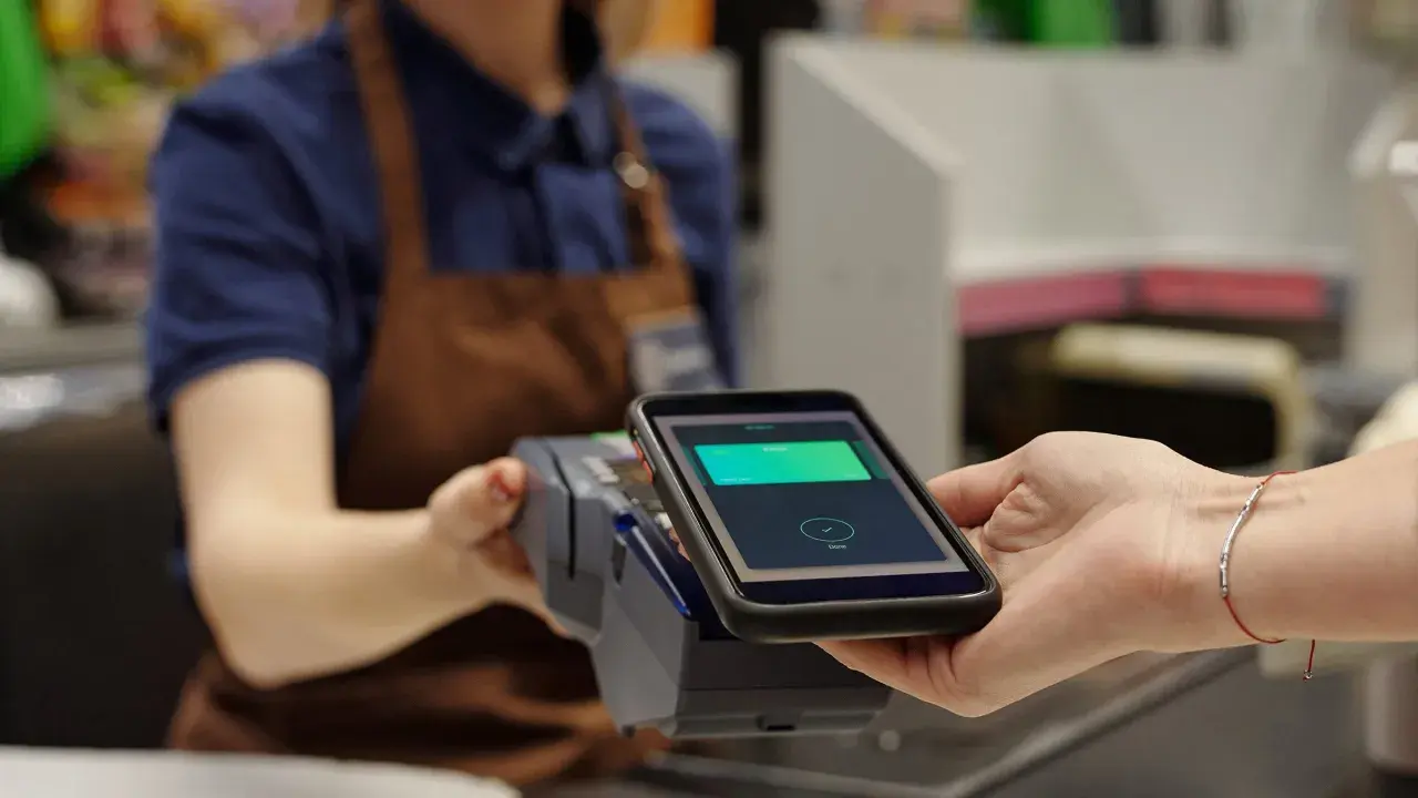 Bezahlvorgang mit Smartphone: Eine virtuelle Kreditkarte wird an einem Terminal abgerechnet.