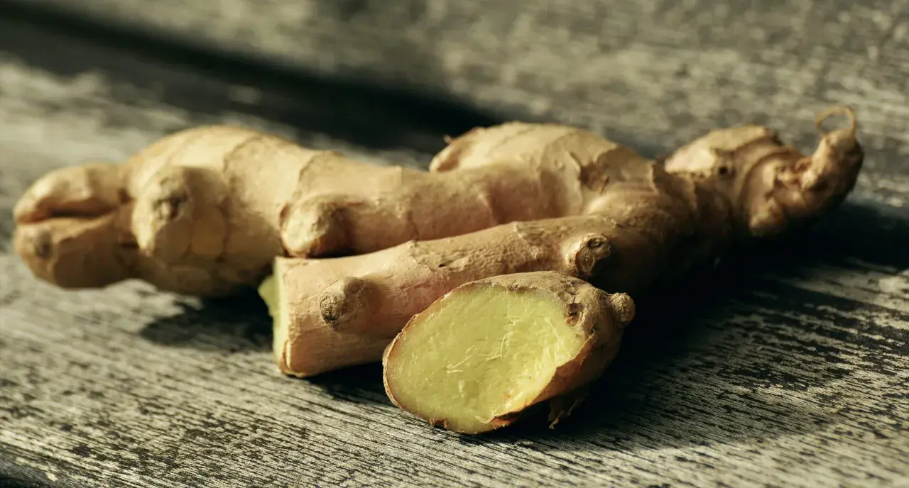 Raíces de jengibre fresco sobre madera, listas para explorar sus usos del jengibre en la cocina, aportando sabor y aroma a tus platos.