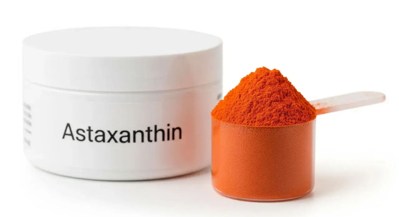 Słoiczek z napisem "Astaxanthin" i miarka pełna pomarańczowego proszku. To właśnie astaksantyna, silny antyoksydant.
