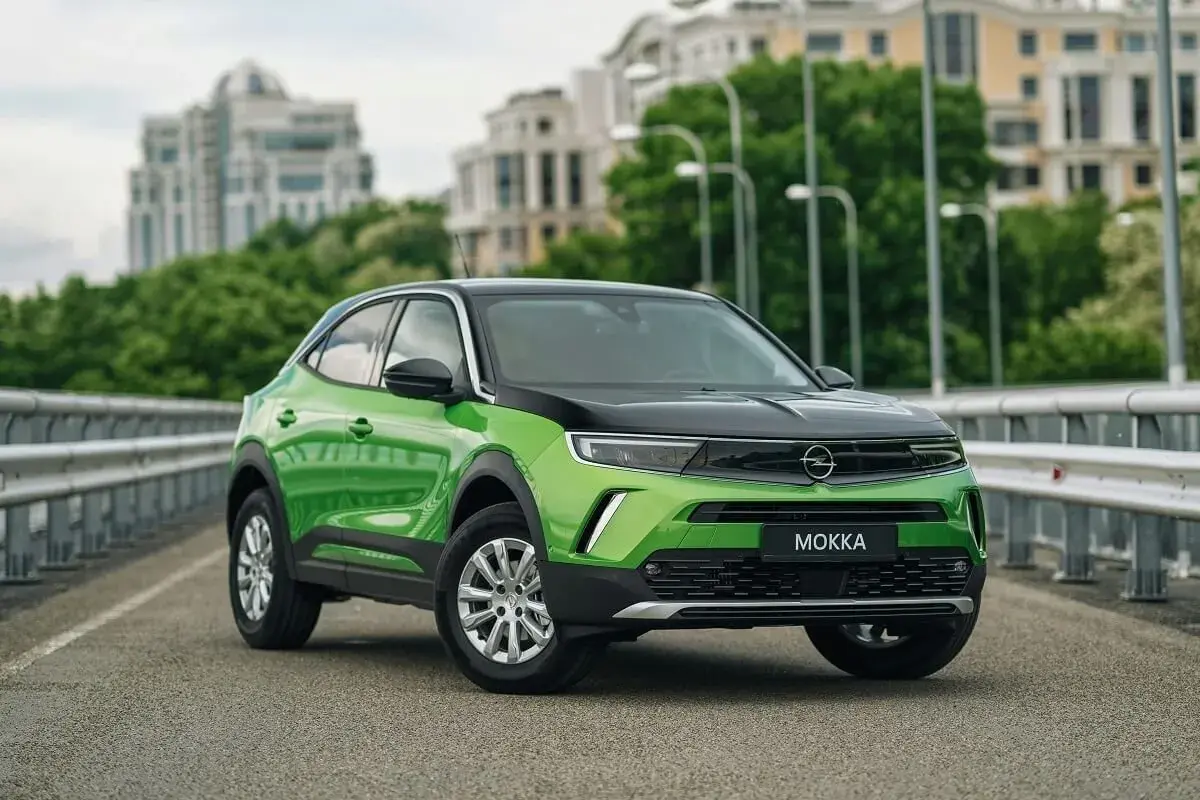 Zielony Opel Mokka na moście, z widocznymi felgami i oponami. Idealny rozmiar opon dla tego miejskiego SUV-a.