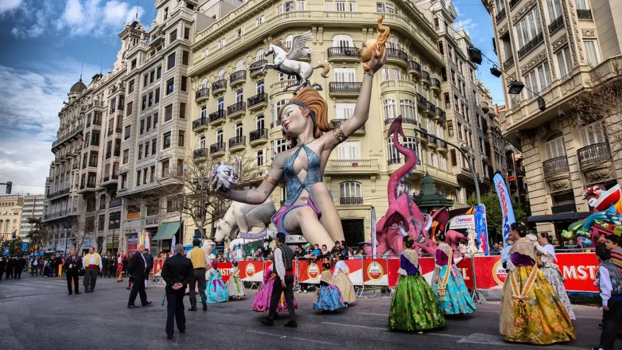 Gigantescas figuras de fantasía, como un dragón rosa y una mujer con un pegaso, dominan la calle en las Fallas 2026.