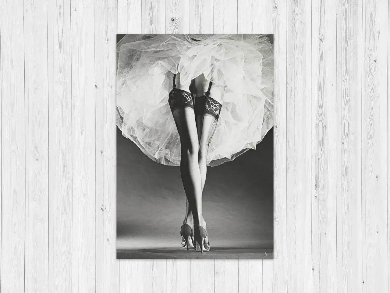 Nogi w pończochach i szpilkach, ukryte pod zwiewną spódnicą. Klasyka w stylu Horst P. Horst.