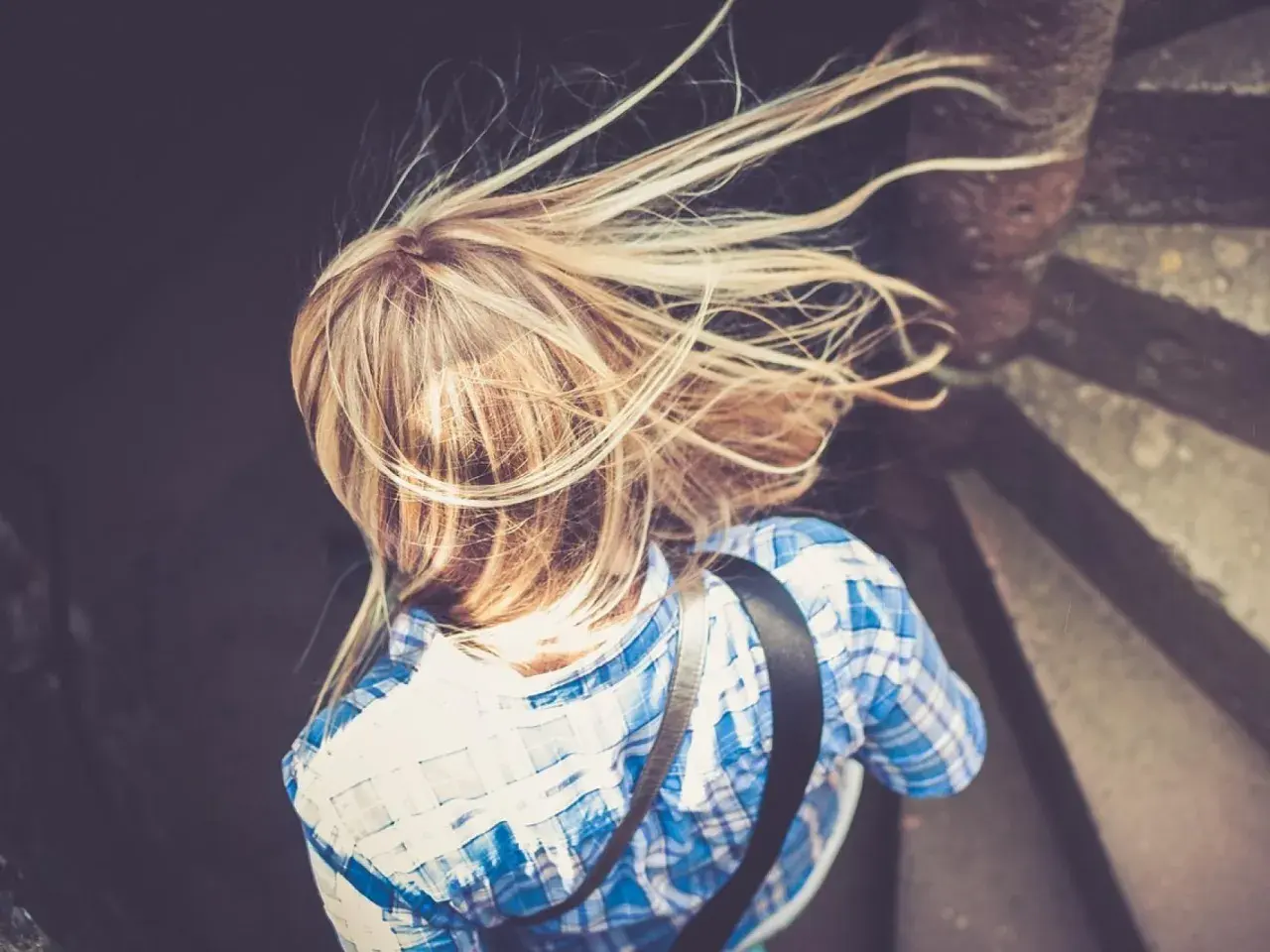 Rubia con pelo al viento, buscando cómo aclarar el pelo naturalmente.