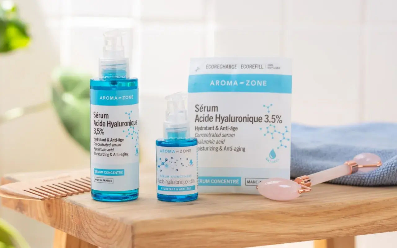 Sérums Aroma-Zone à l'acide hyaluronique pour une peau hydratée et anti-âge. Un rouleau de jade rose complète ce rituel de soin.