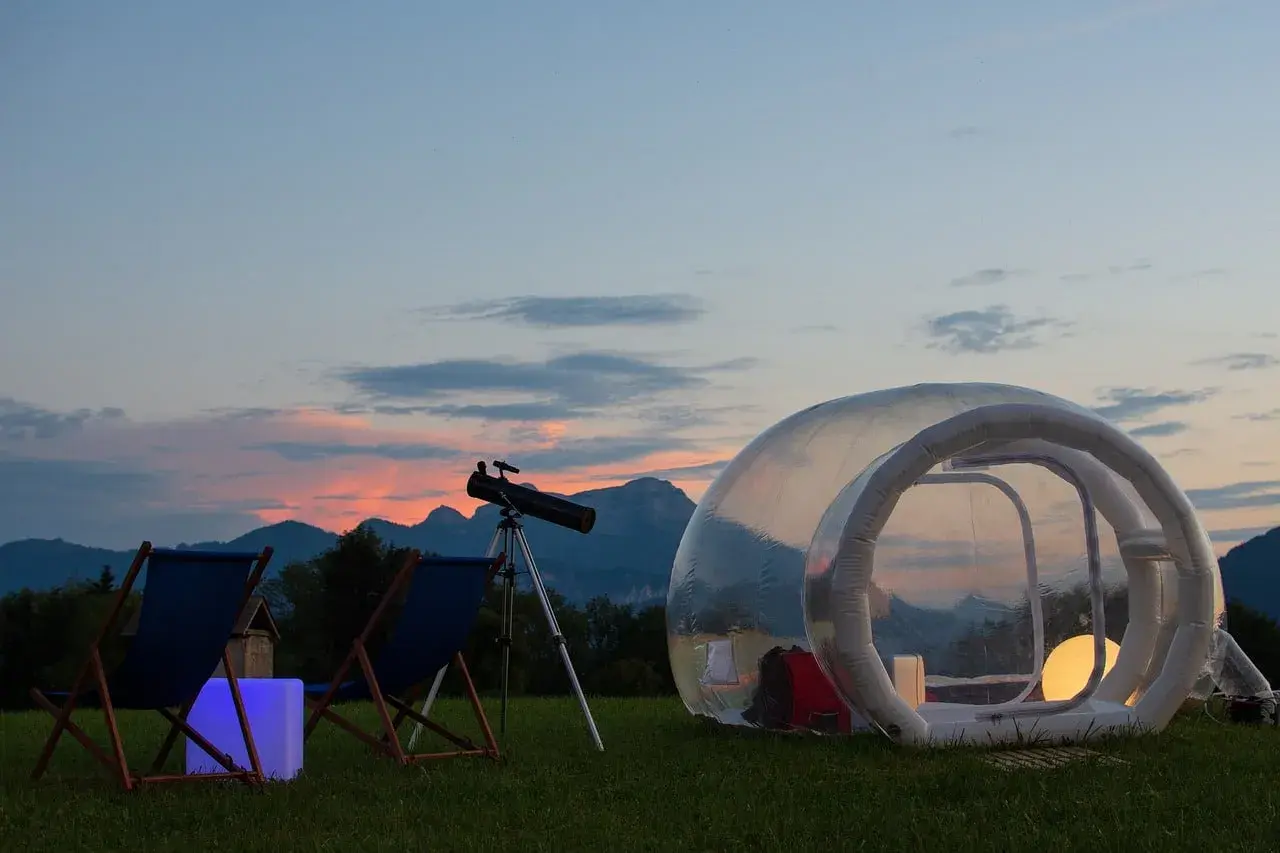 Un lieu insolite autour de Nice : une bulle transparente pour observer les étoiles, avec télescope et chaises longues, au coucher du soleil.