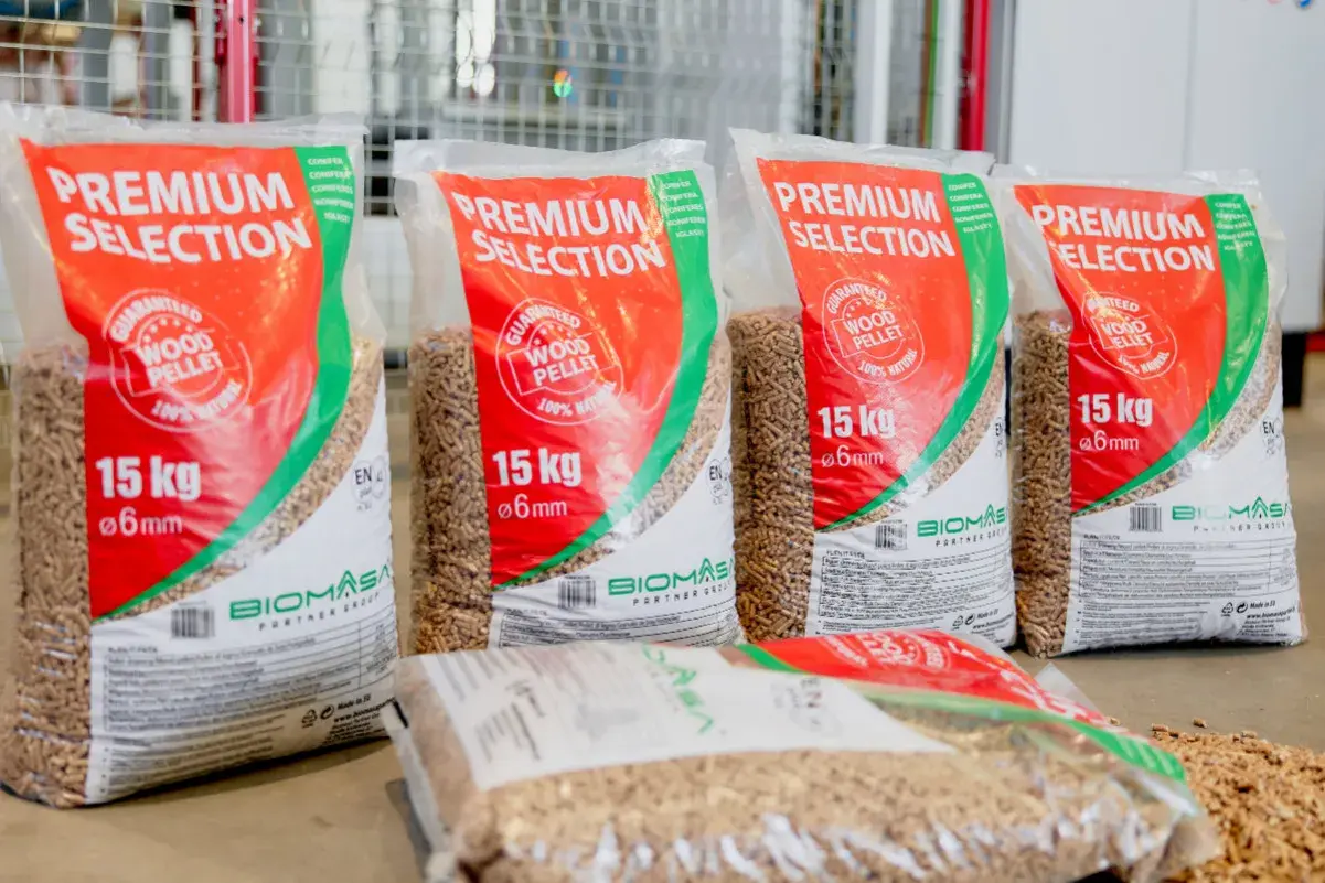 Kilka worków z napisem "PREMIUM SELECTION" zawierających pellet drzewny premium. Każdy worek waży 15 kg i zawiera pellet o średnicy 6 mm.