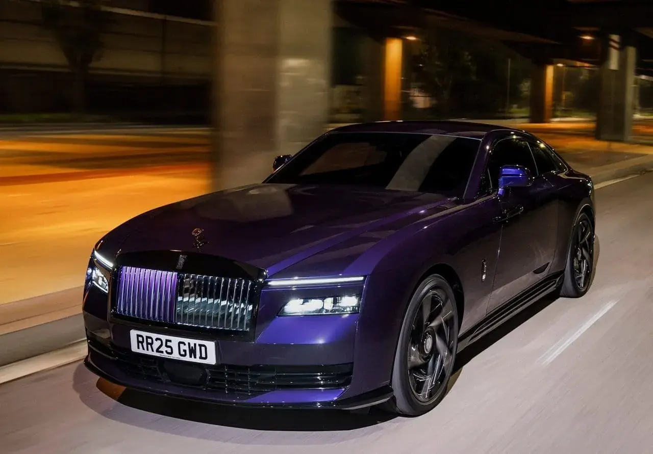 Fioletowy Rolls-Royce Ghost na nocnej drodze. Zastanawiasz się nad rolls royce cena?