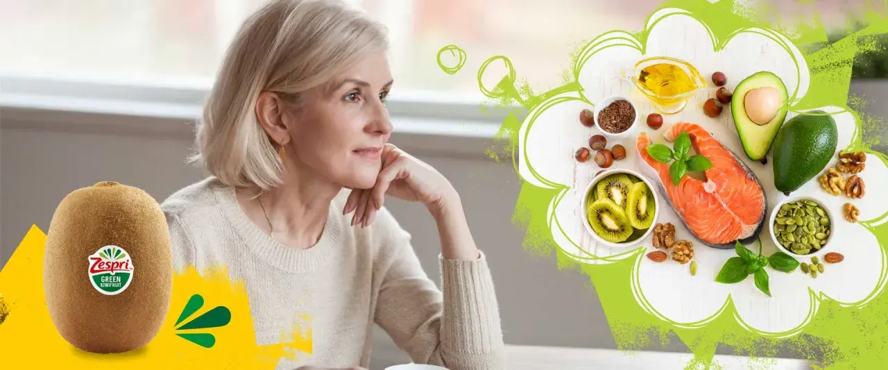 Äldre kvinna funderar över hälsosam mat med lax, avokado, nötter och kiwi. Fett som en del av en balanserad kost.