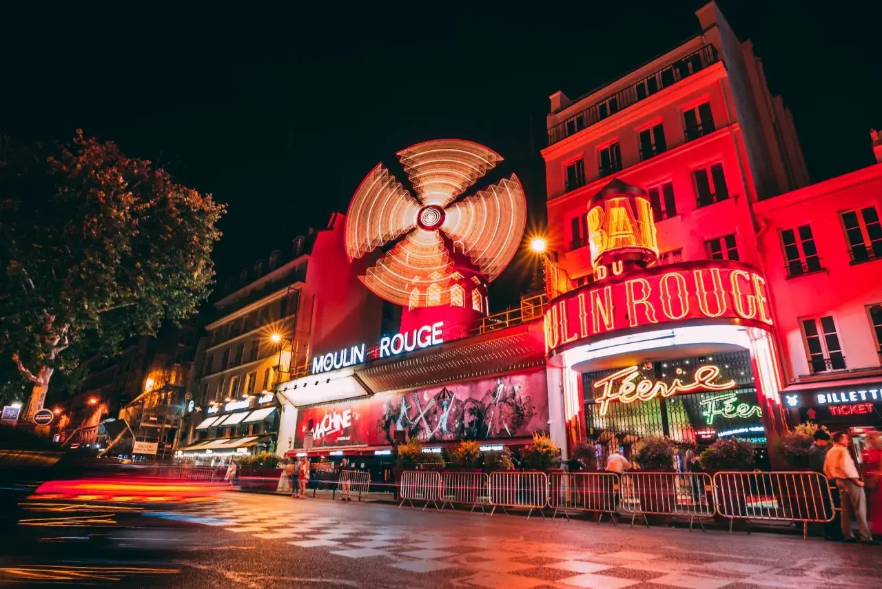 Nocny Paryż rozświetlony neonami. Słynny kabaret Moulin Rouge z wirującym wiatrakiem na dachu zaprasza na wieczór pełen wrażeń.