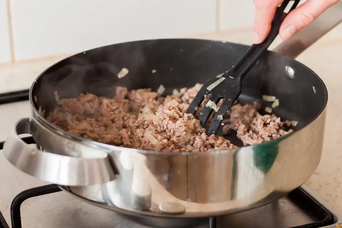 Mielone mięso z cebulą smaży się na patelni, tworząc aromatyczny soboro.