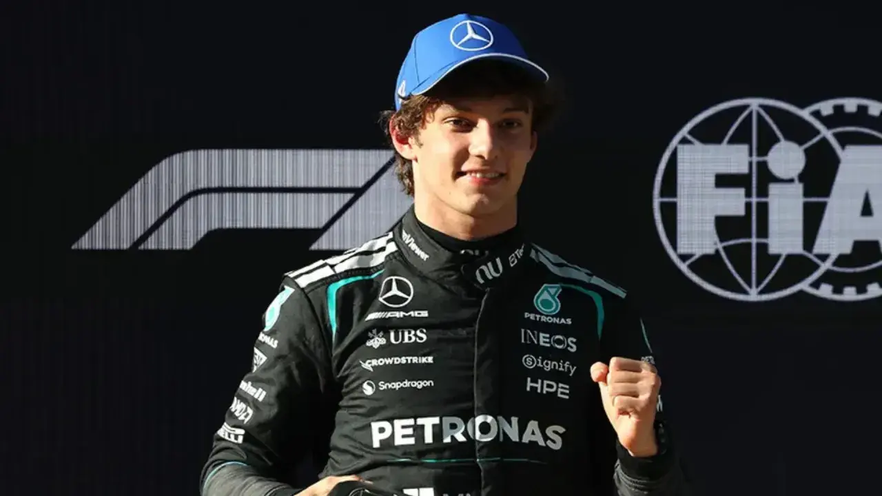 George Russell, piloto de Fórmula 1, celebra con un puño cerrado. Las noticias de Fórmula 1 lo muestran con el logo de Mercedes y FIA.