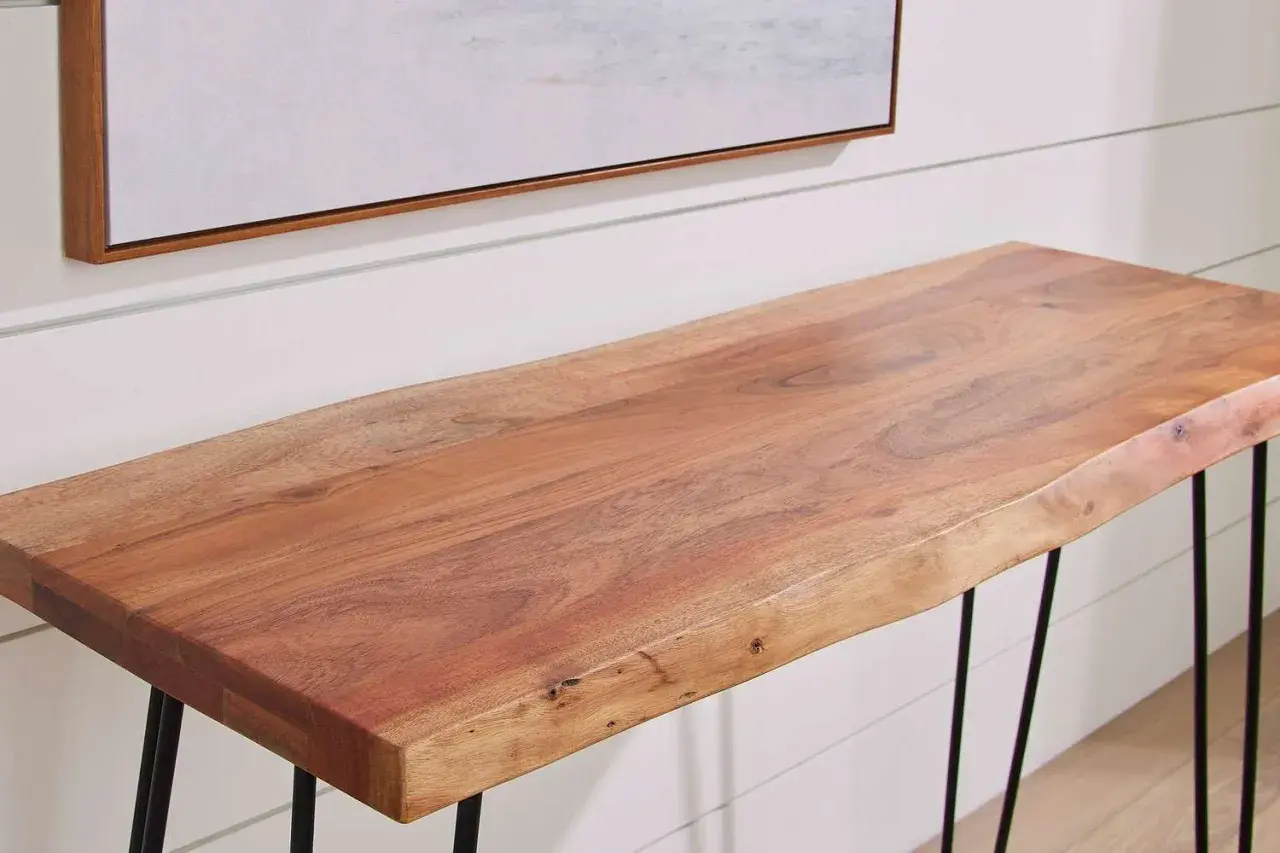 A live-edge acacia wood console table with black hairpin legs, showcasing the natural grain and warmth of the wood.