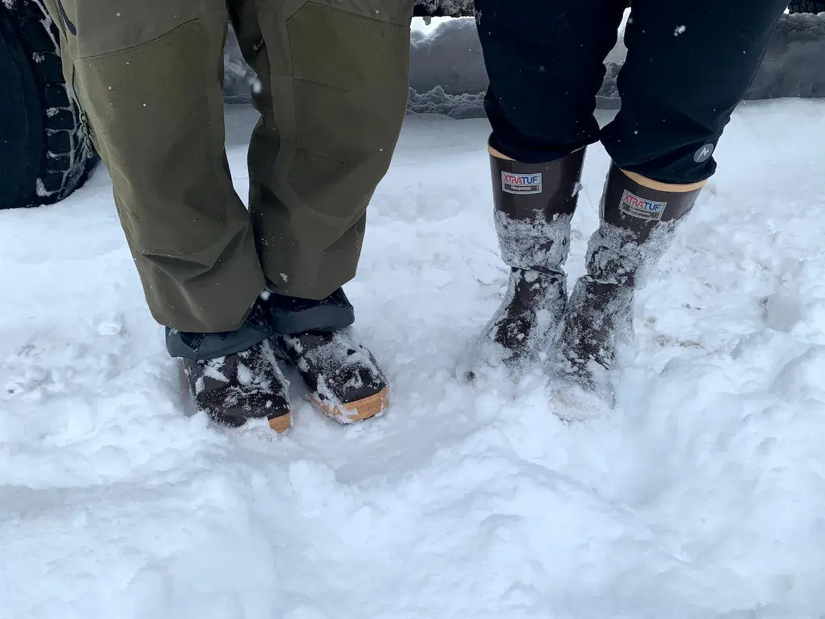 Two pairs of winter boots in snow. The Xtratuf boots fit snugly, allowing for thick socks.