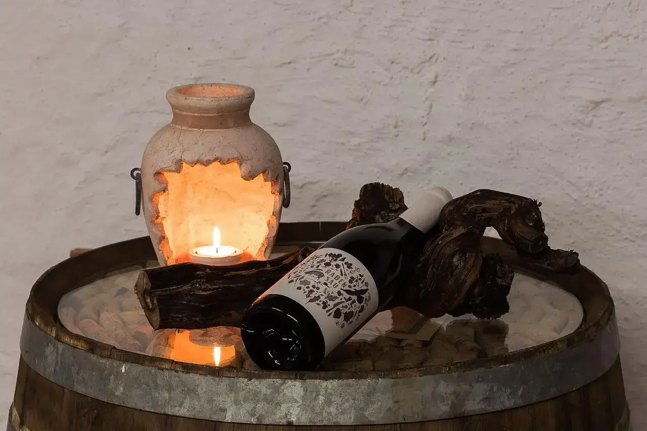Kerzenlicht erhellt eine Flasche Wein, die auf einem Holzstück liegt. Hoffentlich wurde kein schlechten wein getrunken.