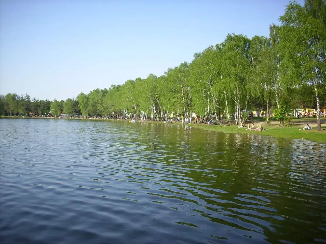 Jezioro Zagłębocze oferuje liczne atrakcje: plażowanie, relaks pod drzewami i zabawy na placu zabaw.