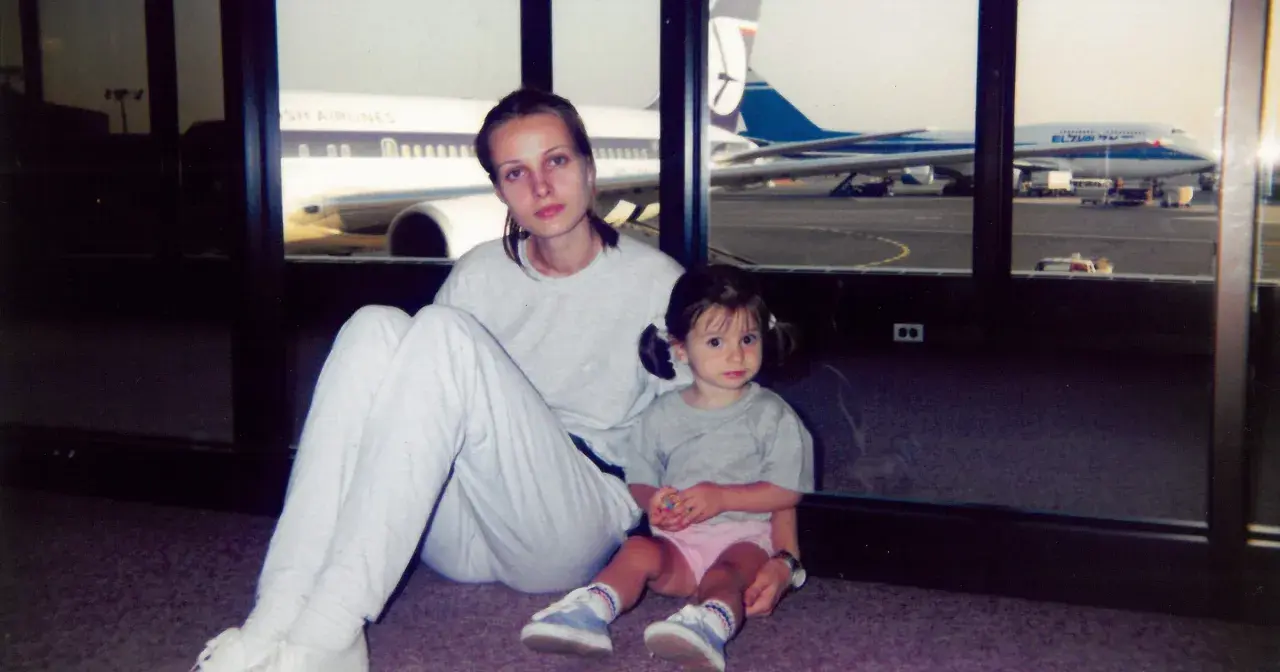 Agnieszka Kotlarska z córką na lotnisku, w tle samoloty British Airways i El Al.