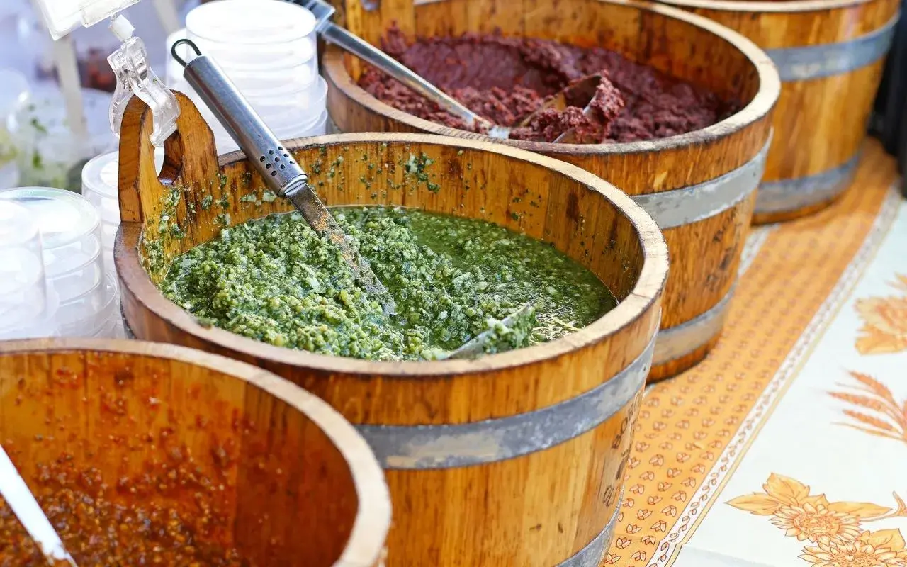 Vari tipi di pesto in botti di legno, un tripudio di sapori freschi e intensi.