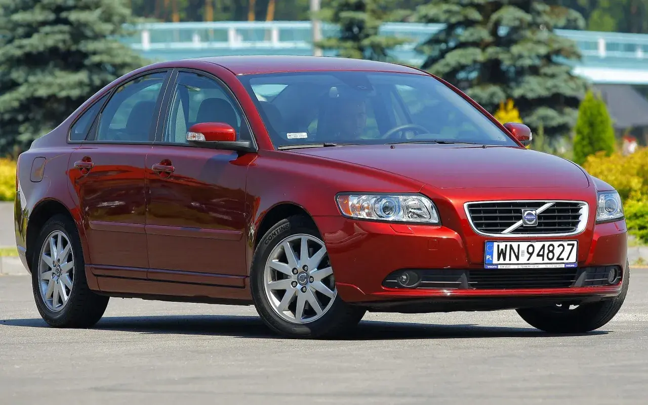Czerwone Volvo S40 II z polskimi tablicami rejestracyjnymi WN 94827 zaparkowane na zewnątrz.