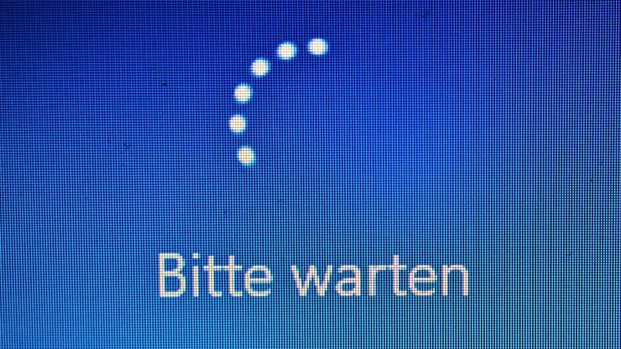 Der PC startet nicht. Ein Ladekreis und die Meldung "Bitte warten" auf blauem Hintergrund deuten auf ein Problem hin.