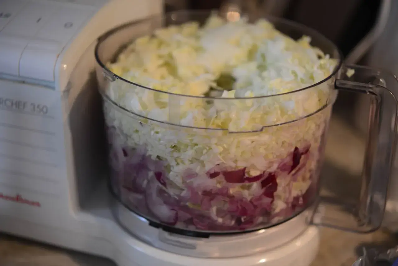 En matberedare fylld med strimlad vitkål och rödlök, redo för en härlig tre veckors sallad.