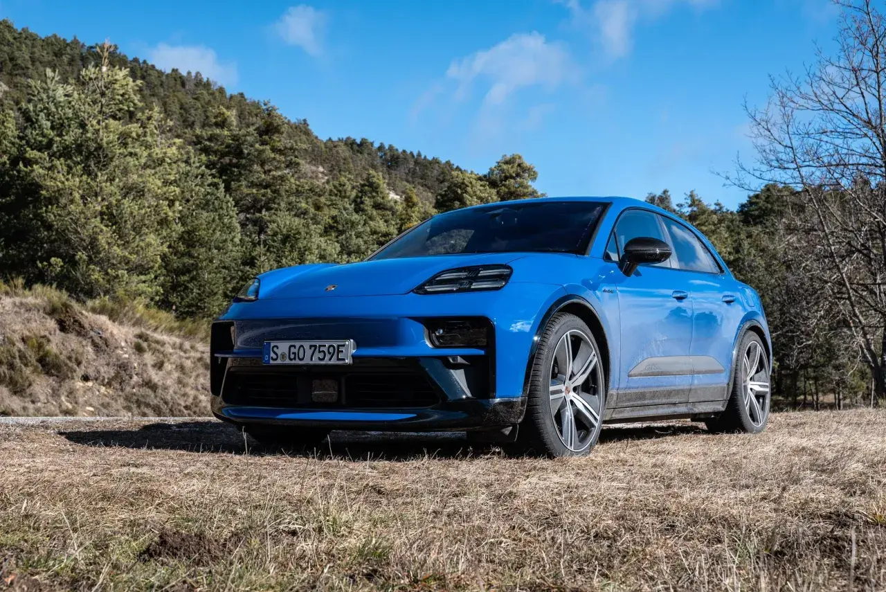 Niebieski Macan GTS na tle leśnego krajobrazu.