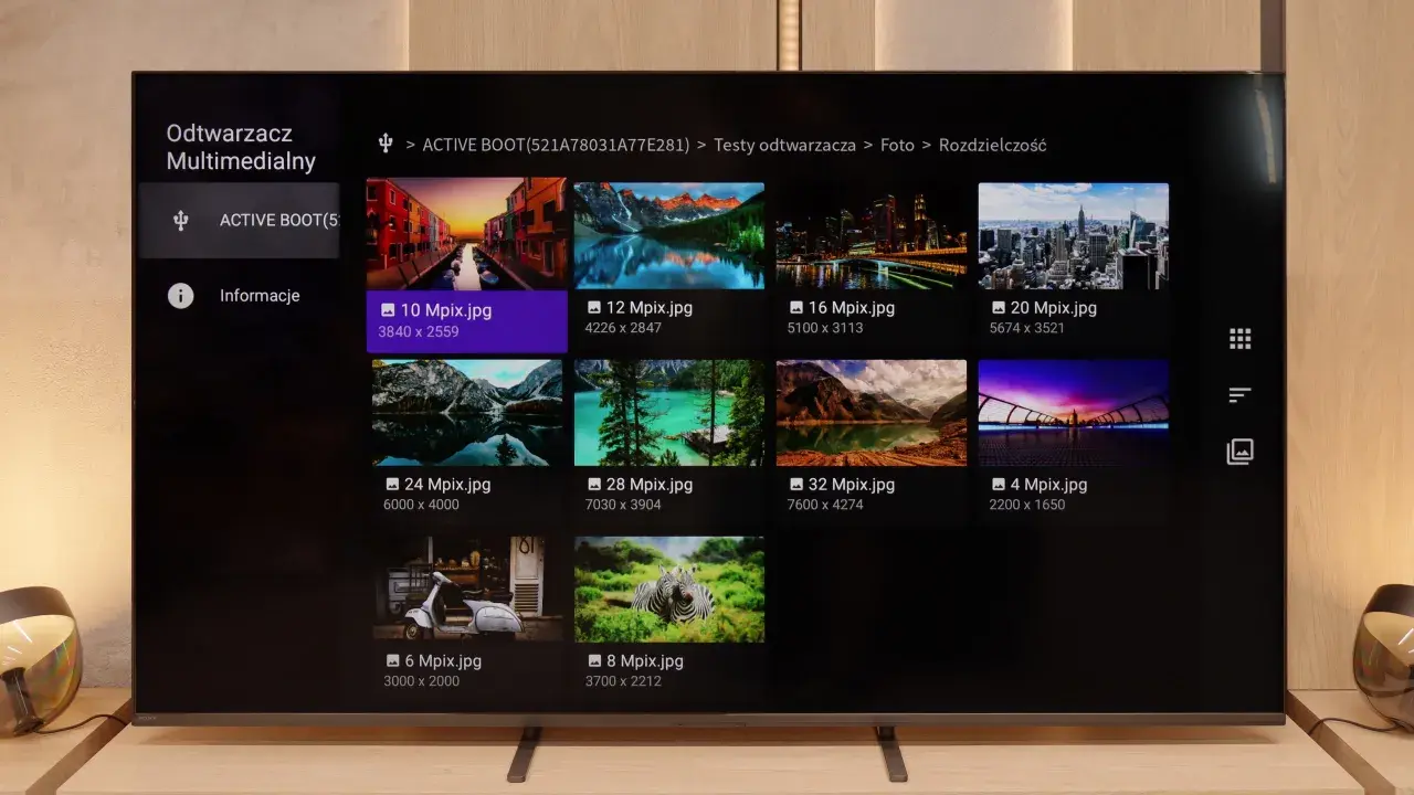 Na ekranie telewizora Sony Bravia 5 wyświetla się interfejs odtwarzacza multimedialnego z miniaturami zdjęć o różnej rozdzielczości.
