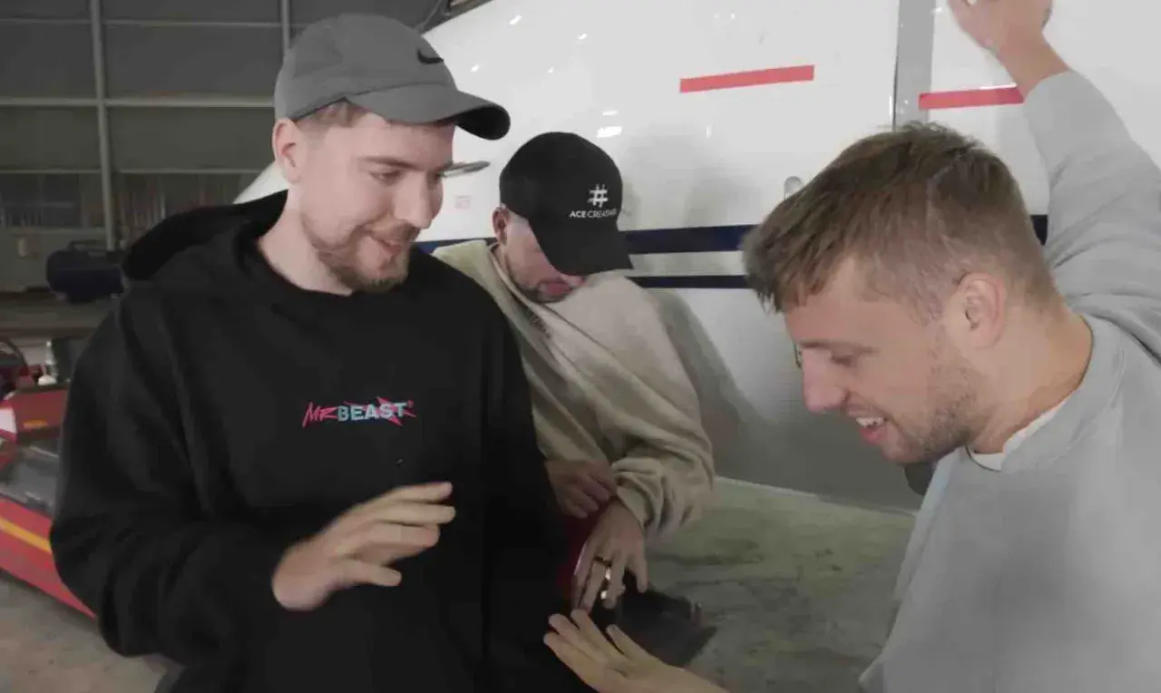 Trzech mężczyzn, w tym MrBeast, stoi obok samolotu. Pytanie "czy Mister Beast żyje" jest nieaktualne, bo widać go w świetnej formie!