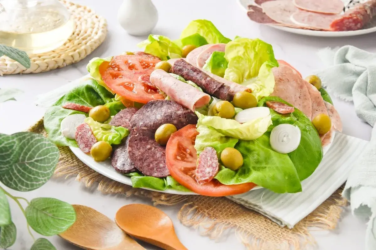 Amanida catalana con lechuga, tomate, aceitunas, cebolla y embutidos variados.
