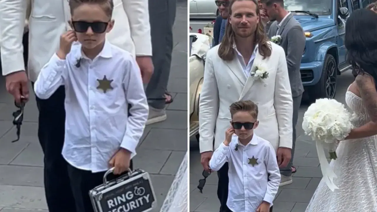 Chłopiec w okularach przeciwsłonecznych, z odznaką i walizeczką "Ring Security", towarzyszy parze młodej.