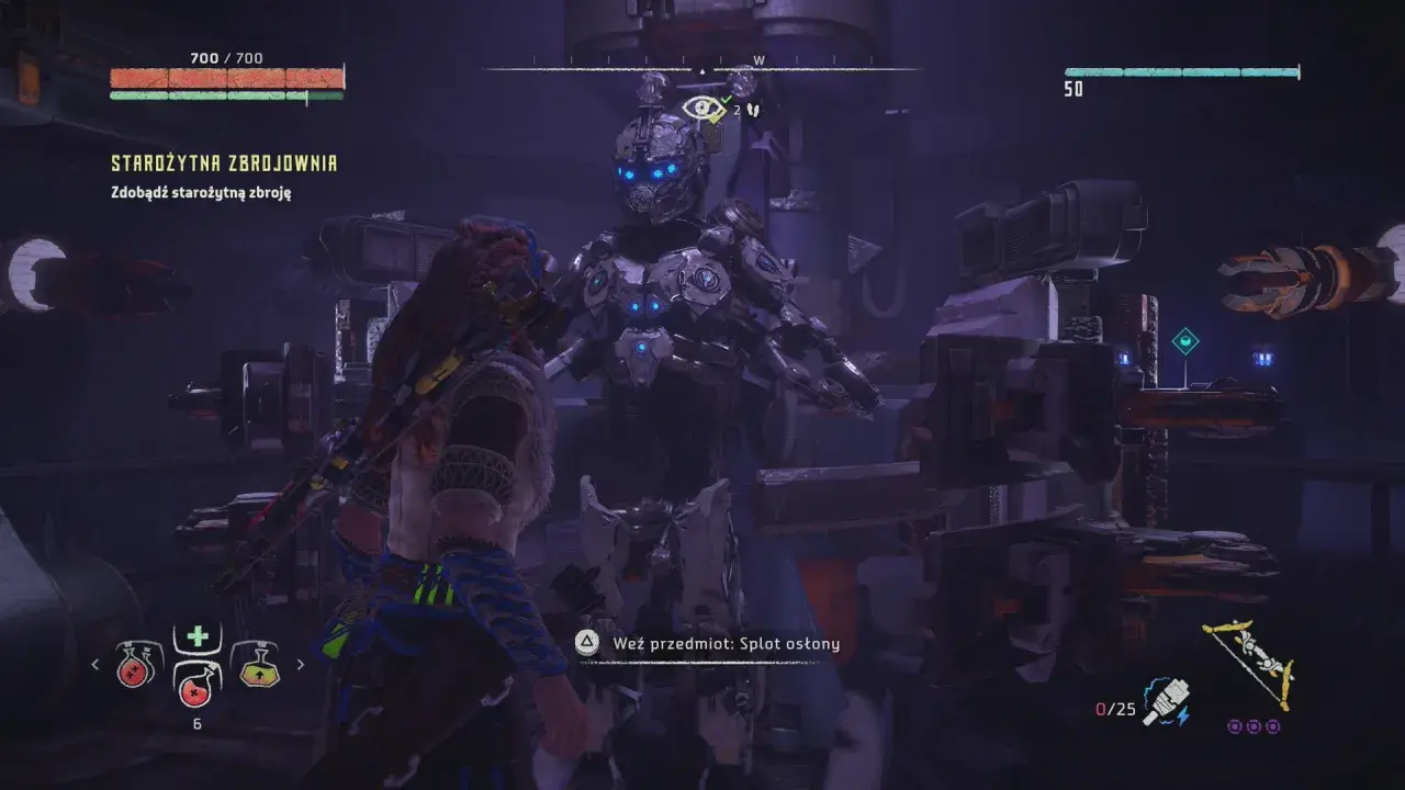 Aloy stoi przed maszyną w starożytnej zbrojowni w Horizon Zero Dawn.