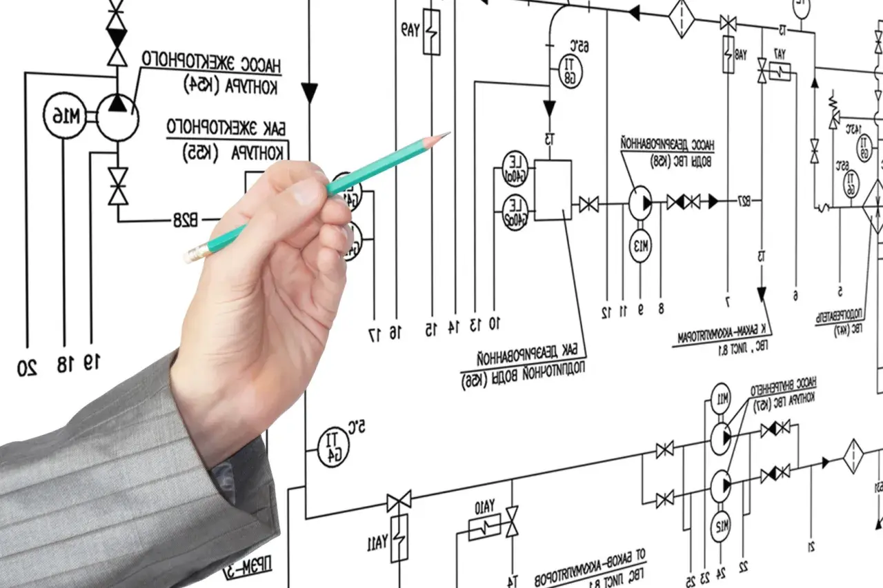 Main d'un homme en costume pointant un schéma technique complexe avec un crayon. Le schéma représente un système de tuyauterie et de vannes, avec des symboles et du texte. Le va et vient des fluides est représenté par des flèches.