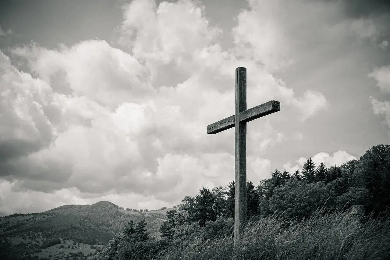 Drewniany krzyż na tle burzowych chmur. Symbolizuje drogę do zrozumienia, jak odróżnić natchnienie boże od własnych pragnień i emocji.