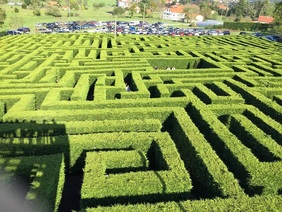 Un laberinto de VillaPresente, con personas explorando sus verdes senderos. ¡Un lugar para perderse y crear recuerdos!